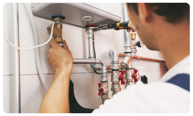 Plumber repairing boiler pipes and fittings for safe heating system maintenance